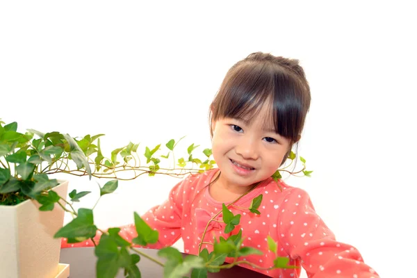 Menina sorridente com planta — Fotografia de Stock