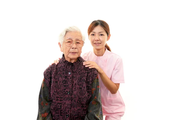 Friendly nurse cares for an elderly woman — Stock Photo, Image