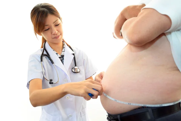 Médico serio examinando la obesidad de un paciente — Foto de Stock