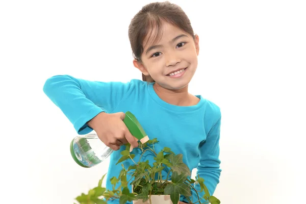 Smiling girl with plant — Stock Photo, Image