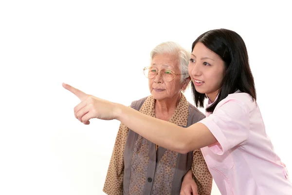 Vriendelijke verpleegster zorgt voor een oudere vrouw — Stockfoto