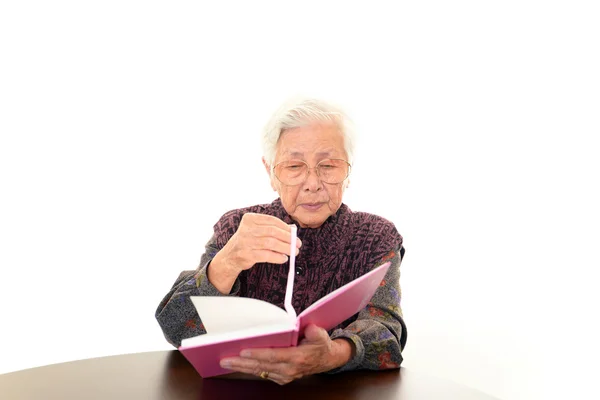 Old woman reading her book — Stock Photo, Image