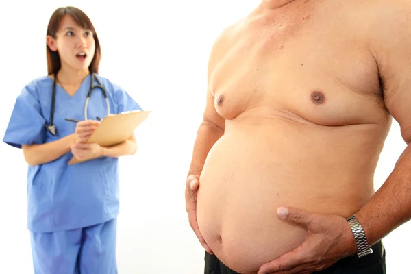 Médico serio examinando la obesidad de un paciente — Foto de Stock