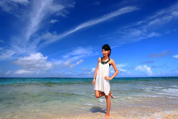 Молодая женщина на пляже наслаждается солнечным светом — стоковое фото