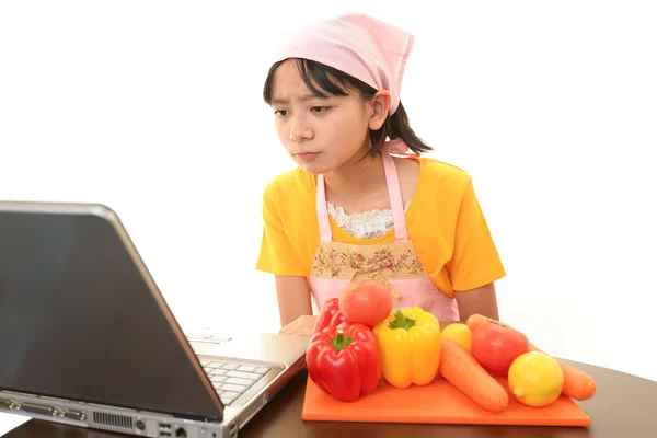 Smiling teenage girl using a laptop — Stock Photo, Image