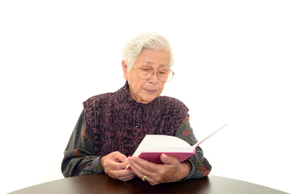 Old woman reading her book — Stock Photo, Image