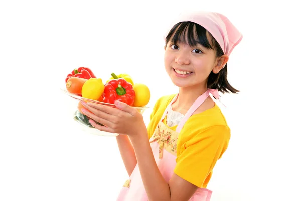 Sorrindo menina segurando legumes — Fotografia de Stock