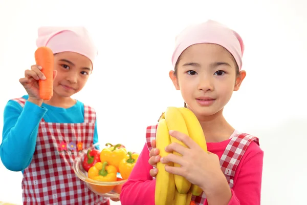 Leende flickor håller frukt — Stockfoto