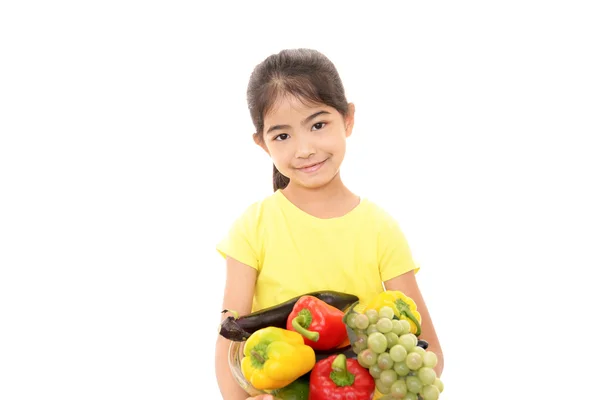 Smiling girl holding vegetables — Stock Photo, Image