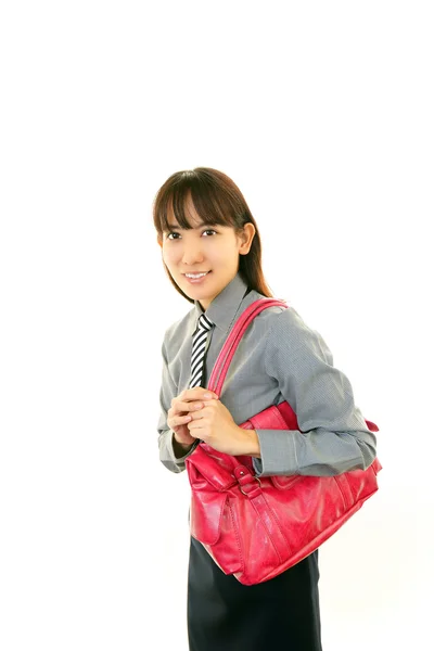 Smiling young woman holding a shoulder bag Stock Photo