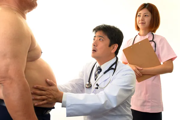 Médico serio examinando la obesidad de un paciente — Foto de Stock