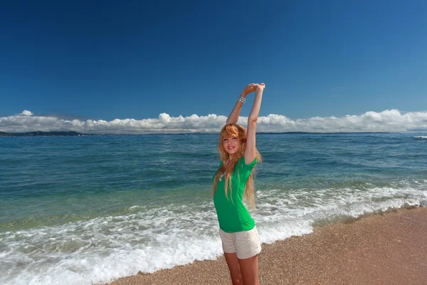 Młoda kobieta robi, rozciągający się na plaży — Zdjęcie stockowe
