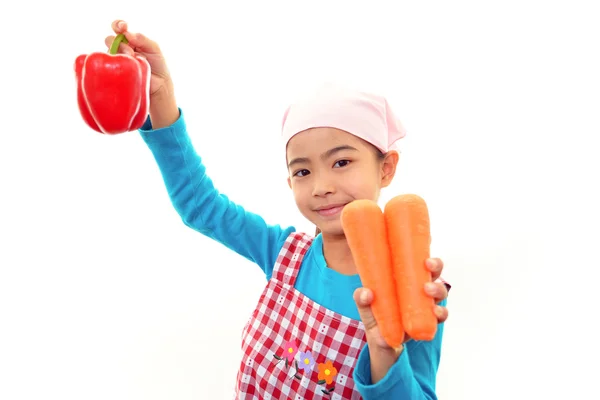 Sonriente chica sosteniendo verduras — Foto de Stock