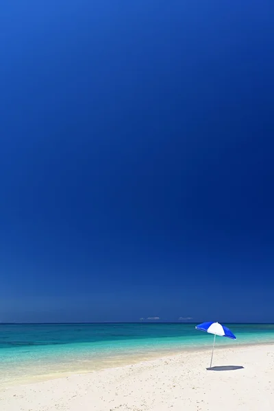 La playa y el paraguas de la playa de mediados de verano . — Foto de Stock