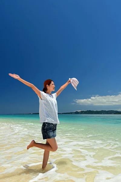 Młoda kobieta na plaży cieszyć się światło słoneczne — Zdjęcie stockowe