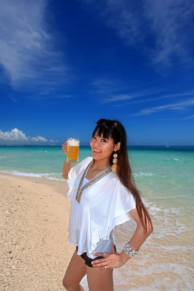 Woman drinking a beer at the beach — Stock Photo, Image