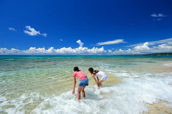 Mor och barn leker på stranden — Stockfoto