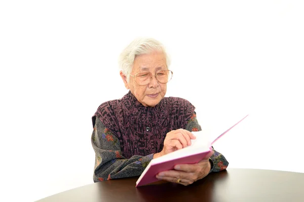 Old woman reading her book — Stock Photo, Image