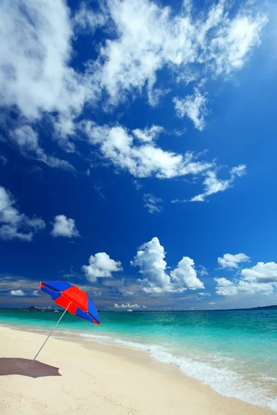 La playa y el paraguas de la playa de mediados de verano . — Foto de Stock