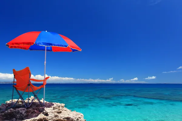 Het strand en het strand-paraplu van midzomer. — Stockfoto