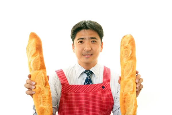 Homem segurando pães — Fotografia de Stock