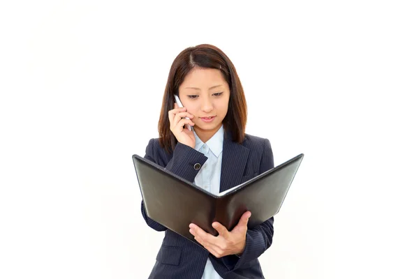 Affärskvinna håller en mobiltelefon och talar — Stockfoto