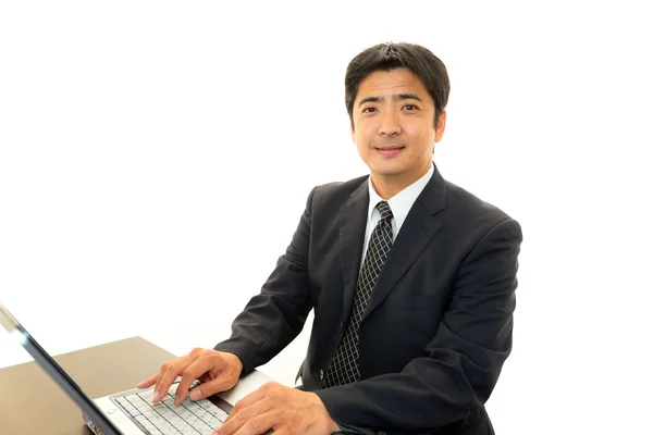 Smiling businessman using laptop, — Stock Photo, Image