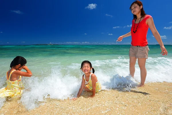 Familie spielt am Strand in Okinawa Stockfoto