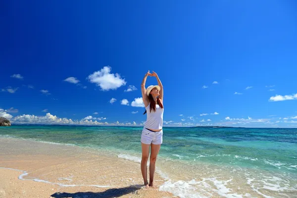 Jeune femme faisant des étirements sur la plage — Photo