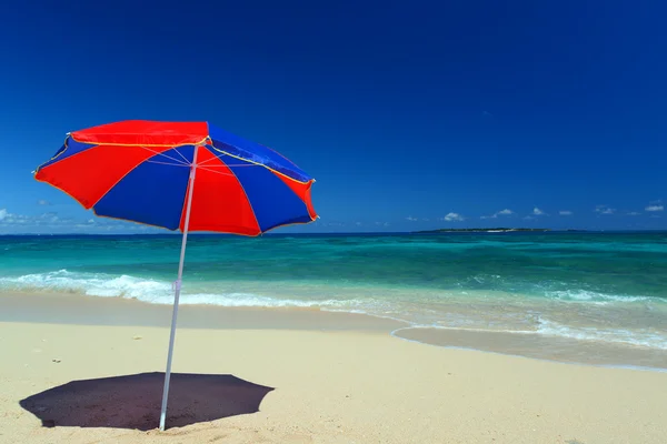 La playa y el paraguas de la playa de mediados de verano . — Foto de Stock