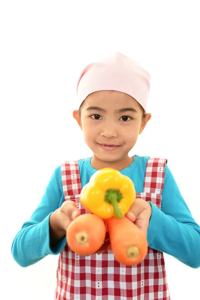 Sorrindo menina segurando legumes — Fotografia de Stock