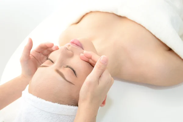 Beautiful young woman receiving facial massage — Stock Photo, Image