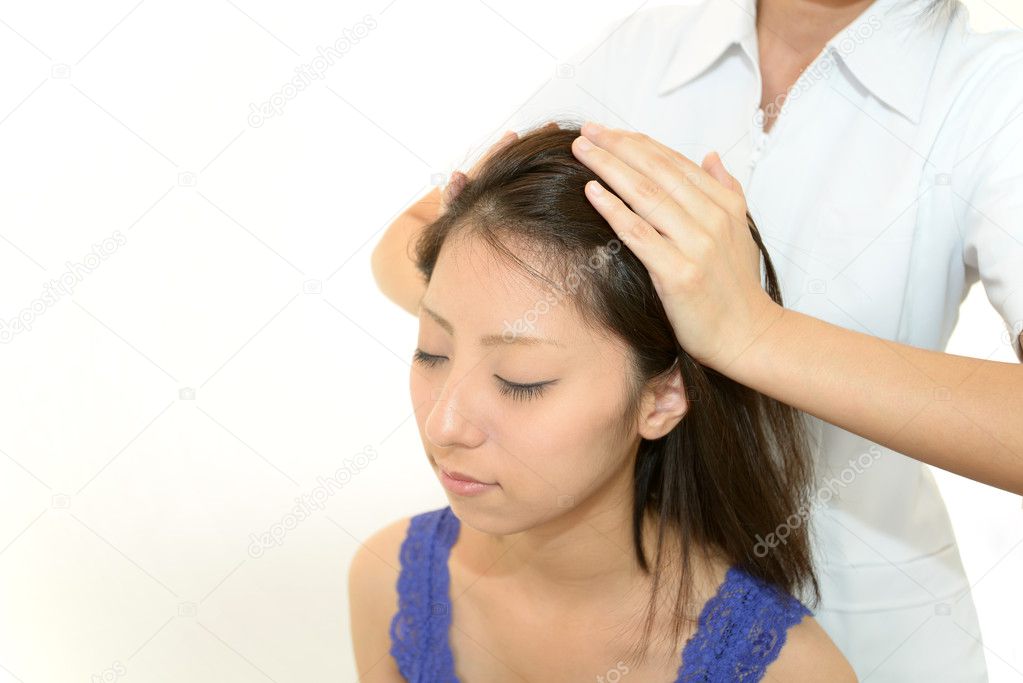 Woman in spa salon receives head massage