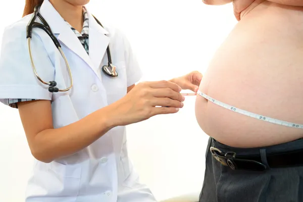 与体检在肥胖病人的女医师 免版税图库图片