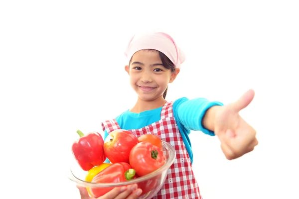 Sonriente chica sosteniendo verduras — Foto de Stock