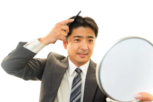 Homem cuidando de seu cabelo — Fotografia de Stock