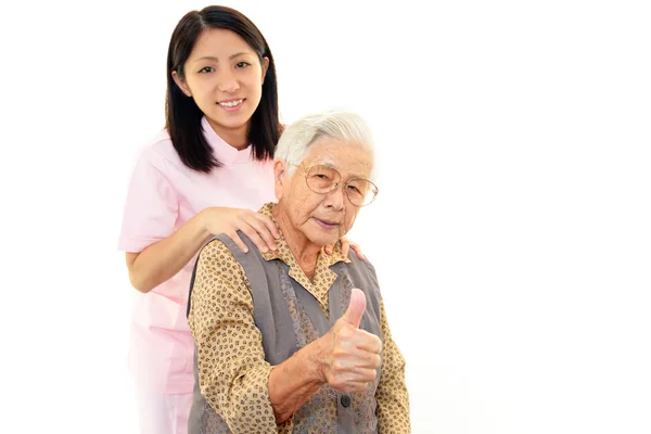 stock image Friendly nurse cares for an elderly woman