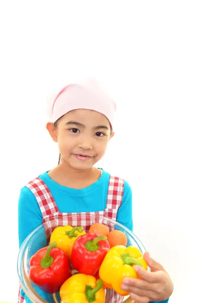 Hymyilevä tyttö tilalla vihanneksia — kuvapankkivalokuva