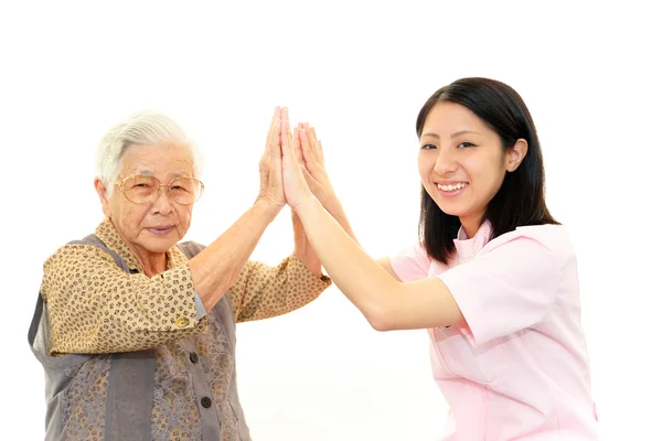 Friendly nurse cares for an elderly woman — Stock Photo, Image