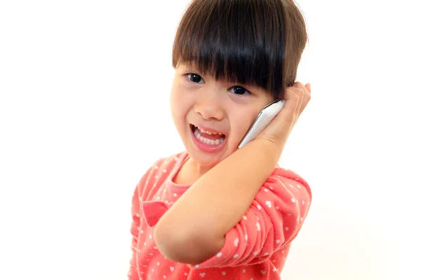 Glückliches kleines Mädchen mit einem Mobiltelefon — Stockfoto