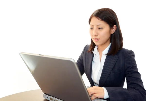 Smiling business woman using laptop — Stock Photo, Image