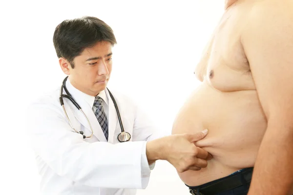 Serious doctor examining a patient obesity — Stock Photo, Image