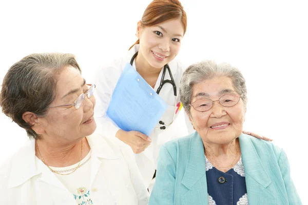 Sonriente médico asiático y las mujeres mayores — Foto de Stock