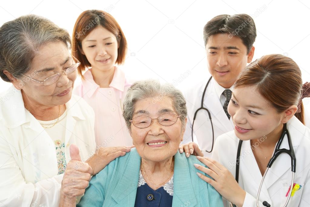 Smiling Asian medical staff with old women