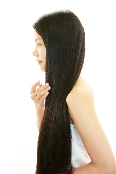 Привлекательная азиатка, ухаживающая за своими волосами — стоковое фото