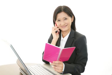 bir cep telefonu tutan ve konuşurken iş kadını