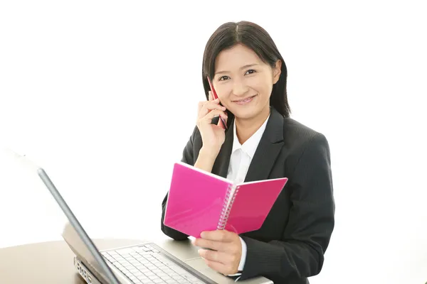 Mulher de negócios segurando um telefone celular e conversando — Fotografia de Stock