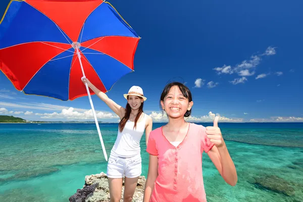 Smiling child with mother on the beach enjoy sunlight — Stock Photo, Image