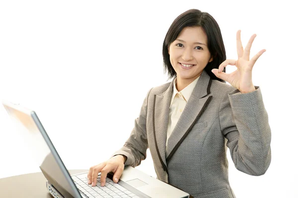 Smiling business woman using laptop — Stock Photo, Image