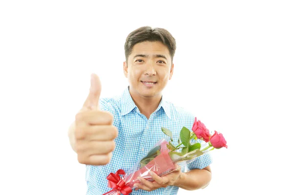 Азиатский мужчина держит букет цветов и улыбается — стоковое фото